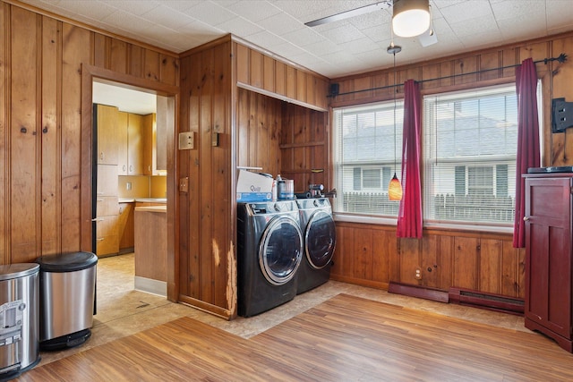 washroom featuring independent washer and dryer, wood walls, laundry area, a ceiling fan, and light wood-style floors