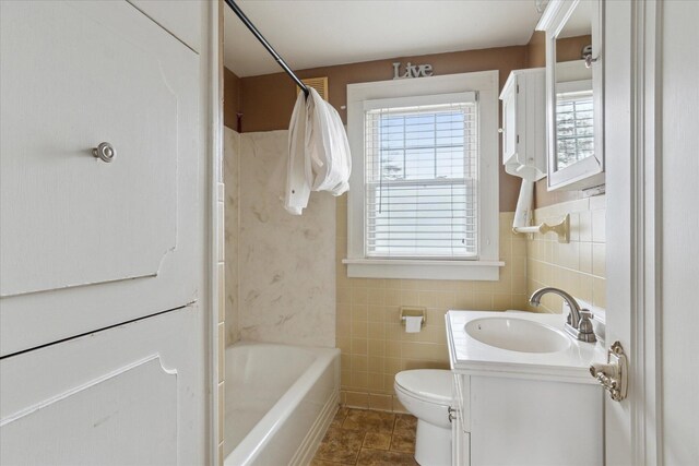 full bath with tile walls, toilet, tile patterned floors, vanity, and shower / tub combo with curtain