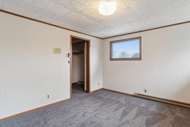 carpeted spare room featuring a baseboard radiator, baseboard heating, baseboards, and ornamental molding