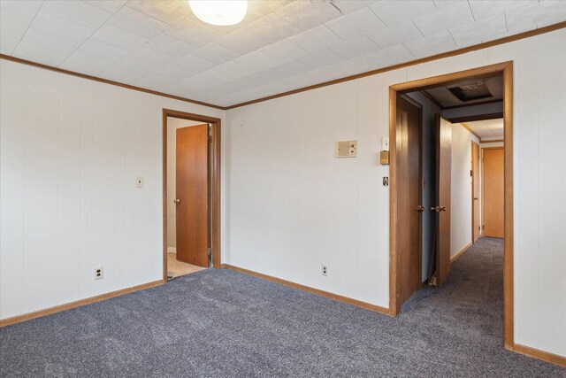 unfurnished room with carpet floors, ornamental molding, and baseboards