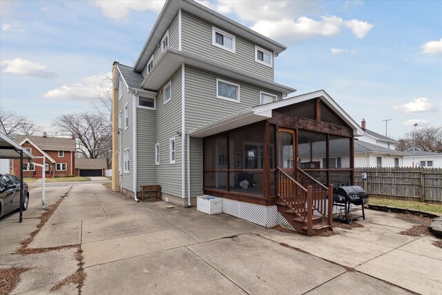 rear view of property with a sunroom and fence