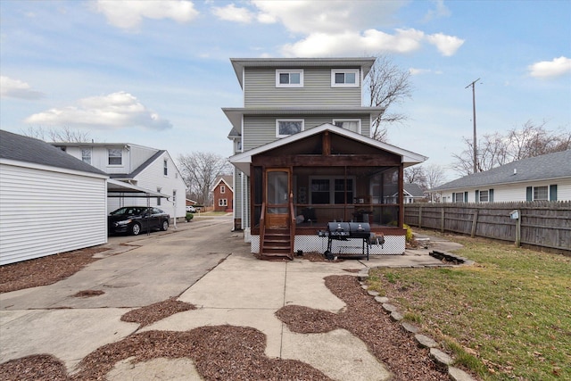 rear view of property featuring a sunroom and fence