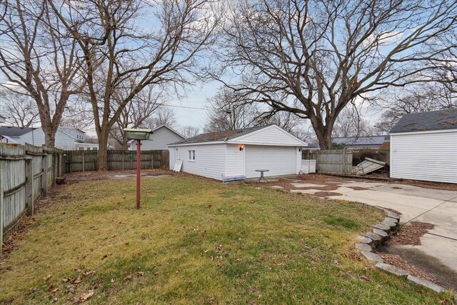 view of yard with an outdoor structure, a fenced backyard, concrete driveway, and a garage