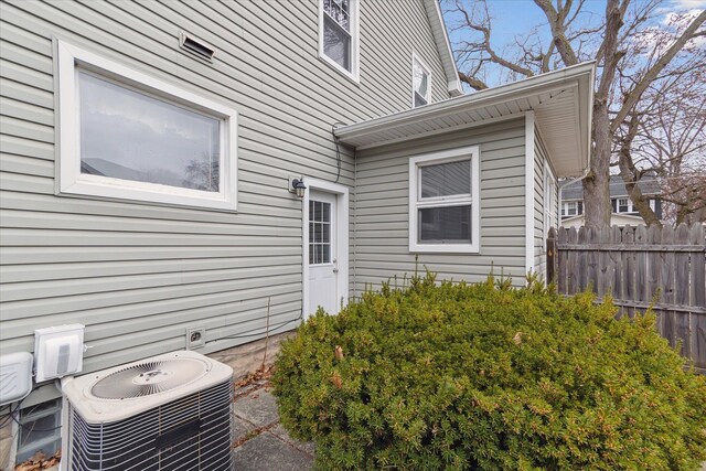 exterior space featuring central AC unit and fence