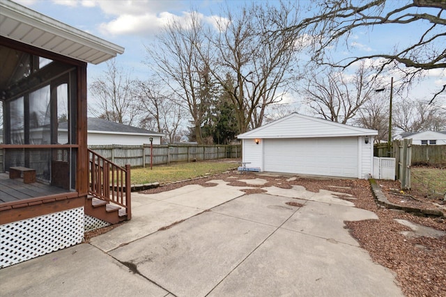 view of patio / terrace featuring an outbuilding, fence, and a garage