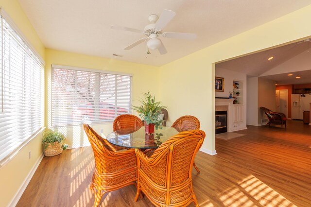 1998 Brighton Ln, Portage, MI 49024 - dining room with a fireplace, wood finished floors, lofted ceiling, and a healthy amount of sunlight