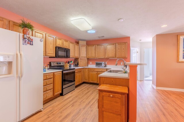 1998 Brighton Ln, Portage, MI 49024 - kitchen with stainless steel electric stove, a sink, white fridge with ice dispenser, light wood-style flooring, and black microwave
