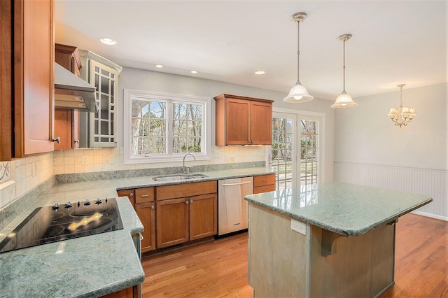 1625 Arlington Blvd, Ann Arbor, MI 48104 - kitchen with stainless steel dishwasher, under cabinet range hood, black electric cooktop, brown cabinetry, and a wainscoted wall