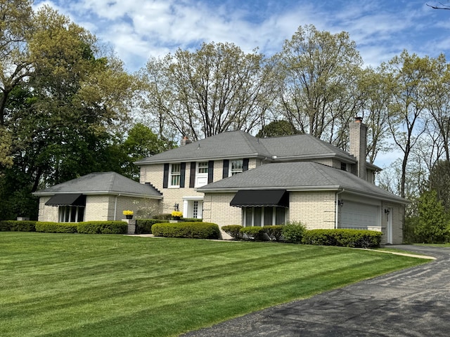 1625 Arlington Blvd, Ann Arbor, MI 48104 - view of front facade with brick siding, an attached garage, a front lawn, and a chimney