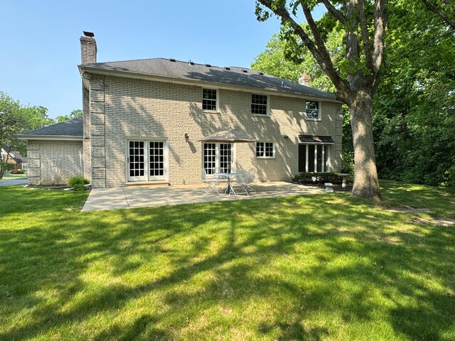 1625 Arlington Blvd, Ann Arbor, MI 48104 - rear view of house with a chimney, french doors, a patio, brick siding, and a lawn