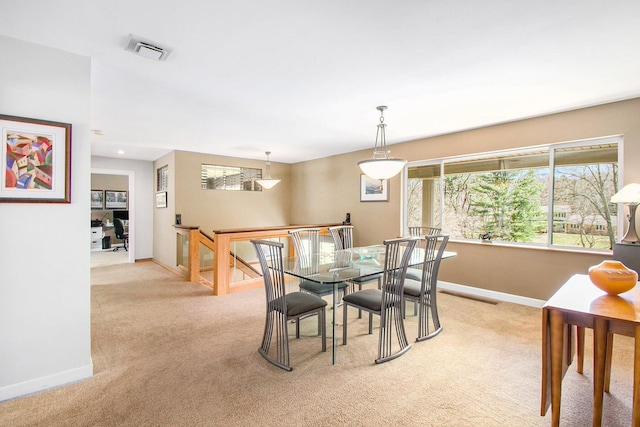 dining room featuring light colored carpet, baseboards, and visible vents
