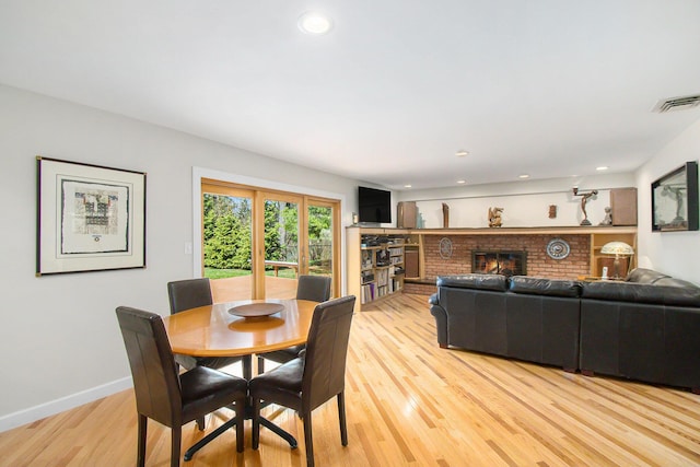 dining area with a fireplace, visible vents, recessed lighting, light wood finished floors, and baseboards