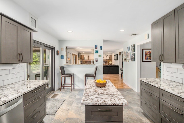 kitchen with visible vents, decorative backsplash, recessed lighting, stainless steel dishwasher, and light stone counters