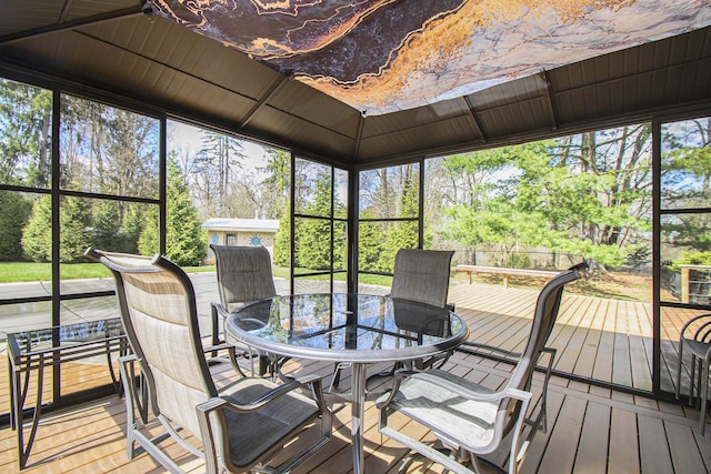 sunroom featuring plenty of natural light and outdoor dining area