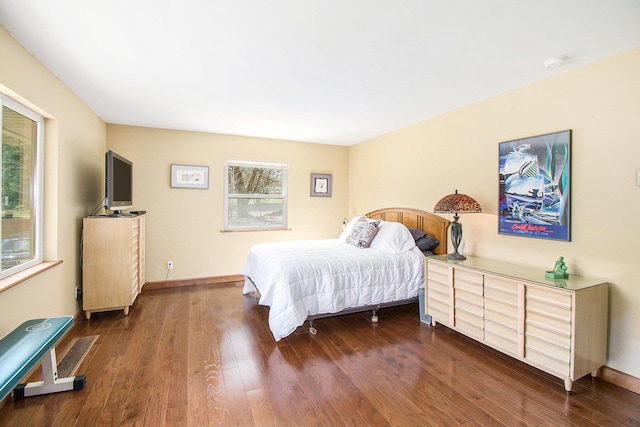 bedroom featuring dark wood-style floors, multiple windows, and baseboards