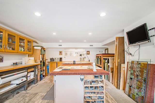 interior space with glass insert cabinets, light wood-style flooring, recessed lighting, and visible vents