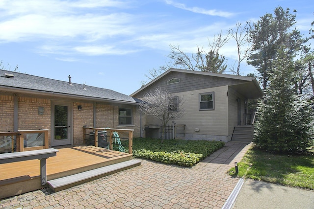 rear view of property featuring a wooden deck