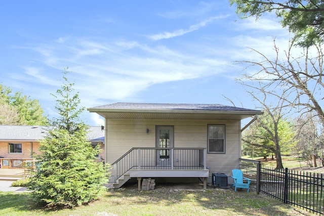 back of house with a shingled roof, fence, covered porch, and central air condition unit
