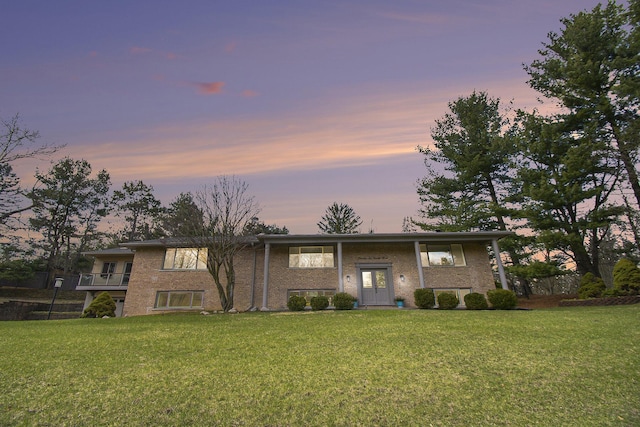 split foyer home with a front yard and brick siding