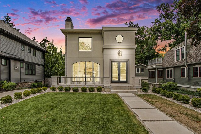 557 Greenwood Ave SE, East Grand Rapids, MI 49506 - view of front of home with a lawn, a chimney, and stucco siding