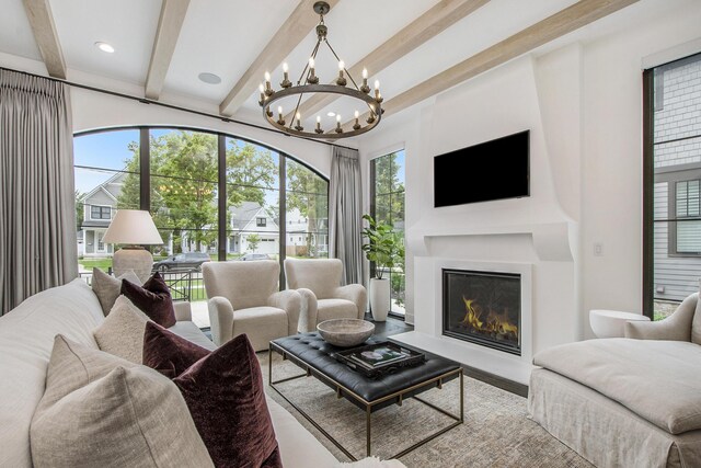 557 Greenwood Ave SE, East Grand Rapids, MI 49506 - living room with beamed ceiling, a wealth of natural light, a glass covered fireplace, and a notable chandelier