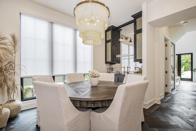 557 Greenwood Ave SE, East Grand Rapids, MI 49506 - dining area with an inviting chandelier, bar area, and baseboards