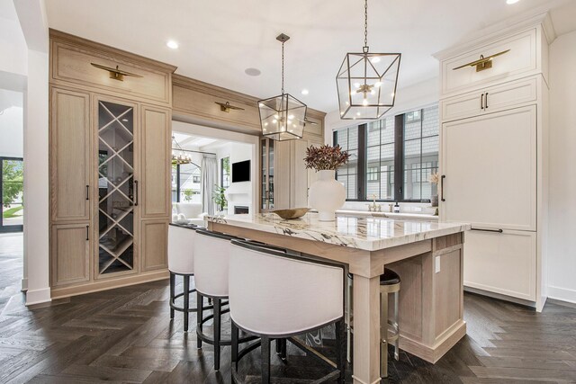 557 Greenwood Ave SE, East Grand Rapids, MI 49506 - kitchen with a center island, a healthy amount of sunlight, a kitchen breakfast bar, and an inviting chandelier