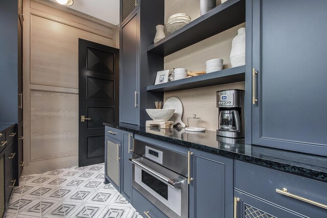 557 Greenwood Ave SE, East Grand Rapids, MI 49506 - kitchen featuring blue cabinetry, dark stone counters, open shelves, and oven