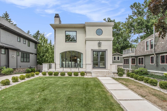 557 Greenwood Ave SE, East Grand Rapids, MI 49506 - view of front facade with stucco siding, a chimney, and a front lawn