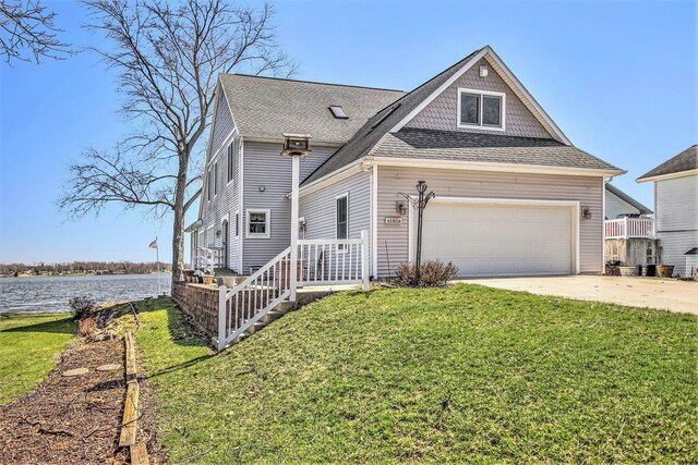 101 Lakeside Dr, Quincy, MI 49082 - view of front of property with roof with shingles, a front yard, a water view, and concrete driveway