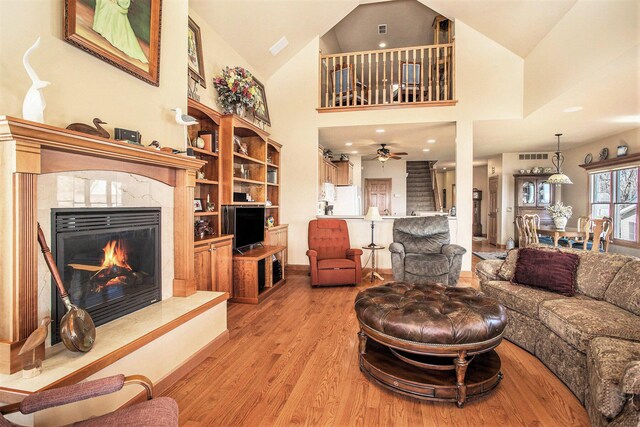 101 Lakeside Dr, Quincy, MI 49082 - living room featuring high vaulted ceiling, a high end fireplace, light wood-style flooring, and ceiling fan
