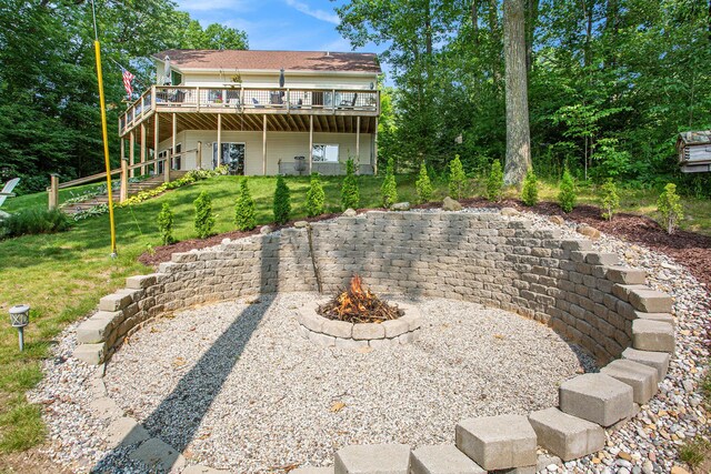 5091 E High Tower Lake Rd, Hesperia, MI 49421 - back of house with an outdoor fire pit, a lawn, and a wooden deck