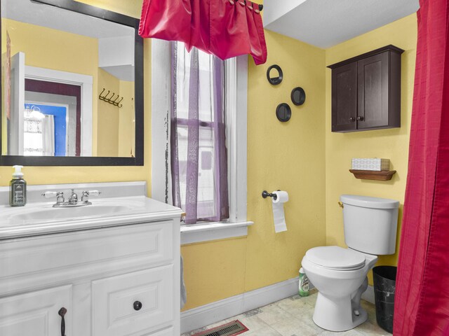 817 E Loomis St, Ludington, MI 49431 - half bathroom featuring baseboards, visible vents, toilet, and vanity