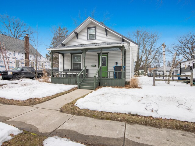 817 E Loomis St, Ludington, MI 49431 - shotgun-style home featuring metal roof and a porch