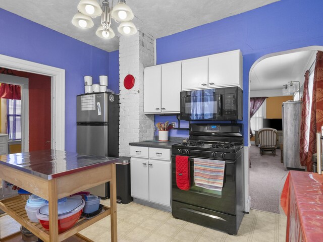 817 E Loomis St, Ludington, MI 49431 - kitchen with a chandelier, white cabinetry, a textured ceiling, dark countertops, and black appliances