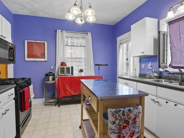 817 E Loomis St, Ludington, MI 49431 - kitchen featuring black appliances, white cabinets, a sink, and an inviting chandelier