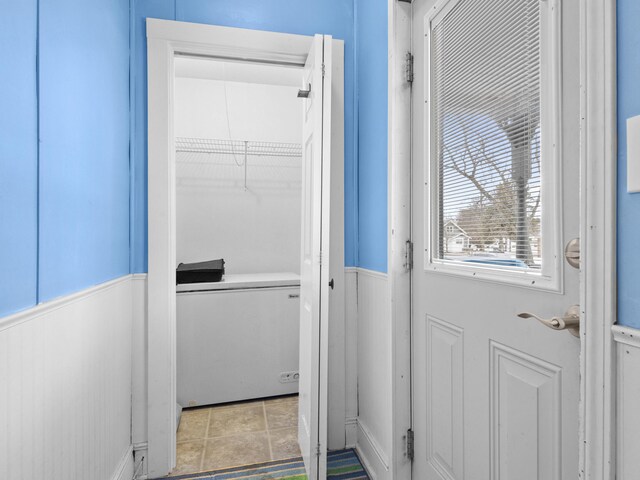 817 E Loomis St, Ludington, MI 49431 - doorway to outside featuring tile patterned floors and wainscoting