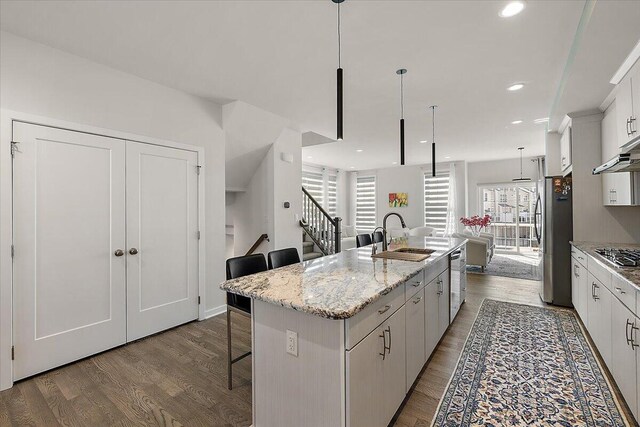 2824 Ridington Rd, Ann Arbor, MI 48105 - kitchen with open floor plan, a breakfast bar area, a center island with sink, a sink, and stainless steel appliances