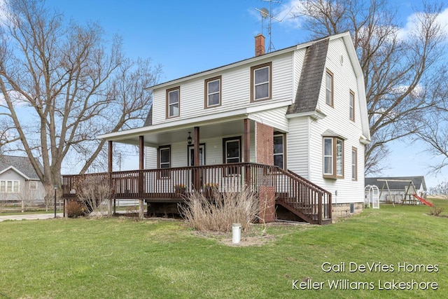 view of front facade featuring a front yard, a gambrel roof, a porch, and roof with shingles