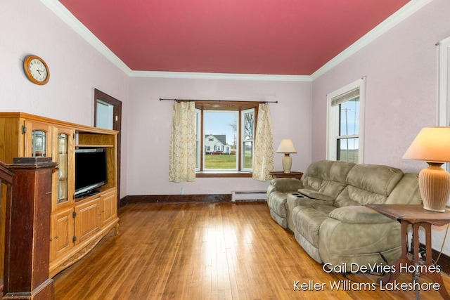 living room with a wealth of natural light, wood finished floors, a baseboard heating unit, and crown molding