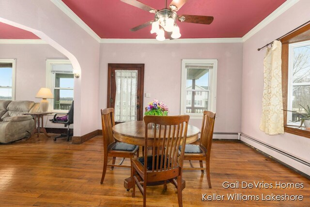 dining room with ornamental molding, wood finished floors, and a ceiling fan