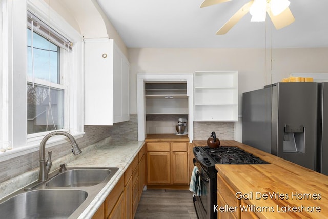 kitchen featuring brown cabinets, butcher block counters, gas stove, a sink, and stainless steel refrigerator with ice dispenser