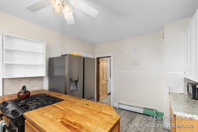 kitchen with black range with gas stovetop, a ceiling fan, stainless steel fridge with ice dispenser, butcher block countertops, and baseboard heating