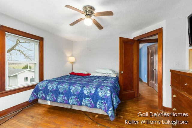 bedroom featuring baseboards, ceiling fan, and wood finished floors