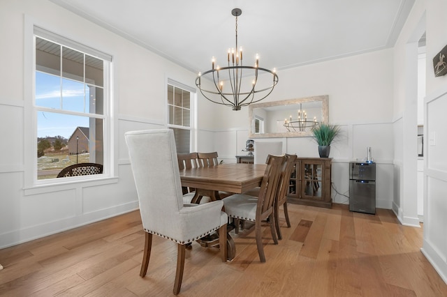 8114 Turning Stone, Kalamazoo, MI 49009 - dining area with a wainscoted wall, a decorative wall, light wood-style flooring, and an inviting chandelier