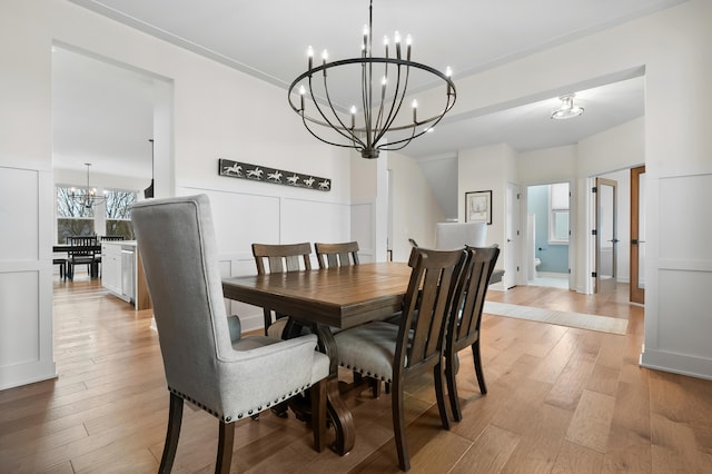 8114 Turning Stone, Kalamazoo, MI 49009 - dining area with a decorative wall, light wood-style flooring, and an inviting chandelier