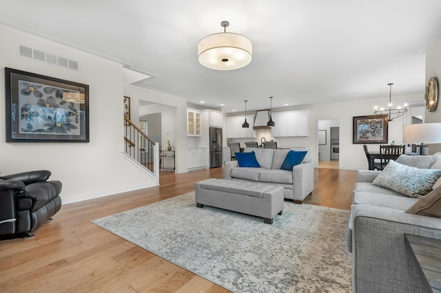 8114 Turning Stone, Kalamazoo, MI 49009 - living room featuring visible vents, light wood-style floors, stairway, and a chandelier