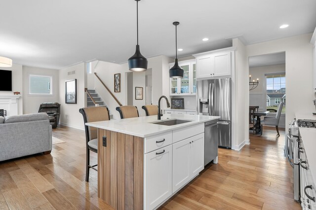8114 Turning Stone, Kalamazoo, MI 49009 - kitchen with open floor plan, a breakfast bar area, a sink, appliances with stainless steel finishes, and glass insert cabinets