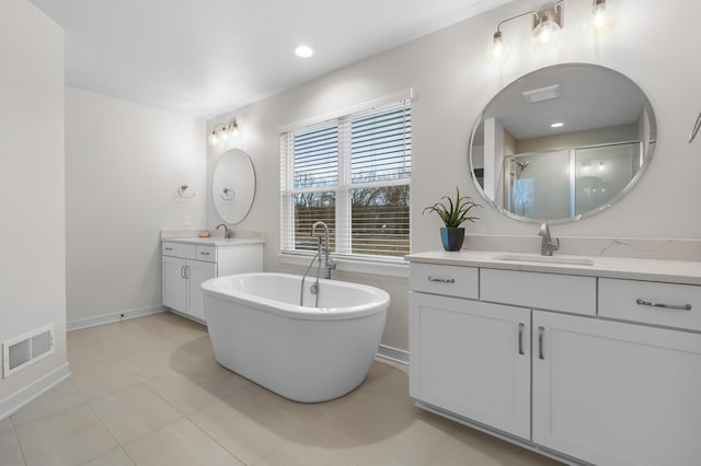 8114 Turning Stone, Kalamazoo, MI 49009 - full bath with visible vents, a soaking tub, a shower stall, two vanities, and a sink