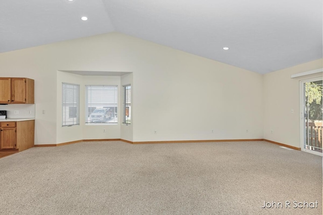 7588 Rivendell Dr SE, Grand Rapids, MI 49508 - unfurnished living room with baseboards, vaulted ceiling, recessed lighting, and light colored carpet